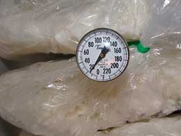 Thermometer between two bags of rice.