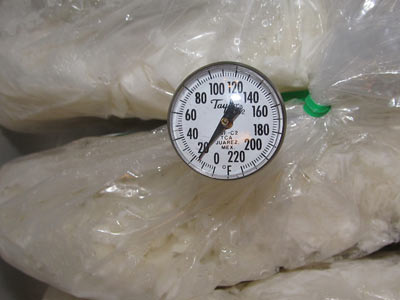 A thermometer between bags of rice